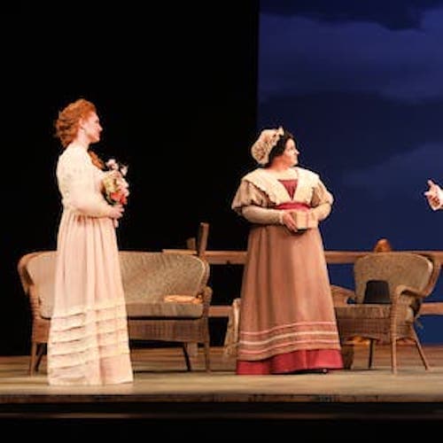 A scene on stage where 4 poorly-dressed people are standing across from someone in uniform.